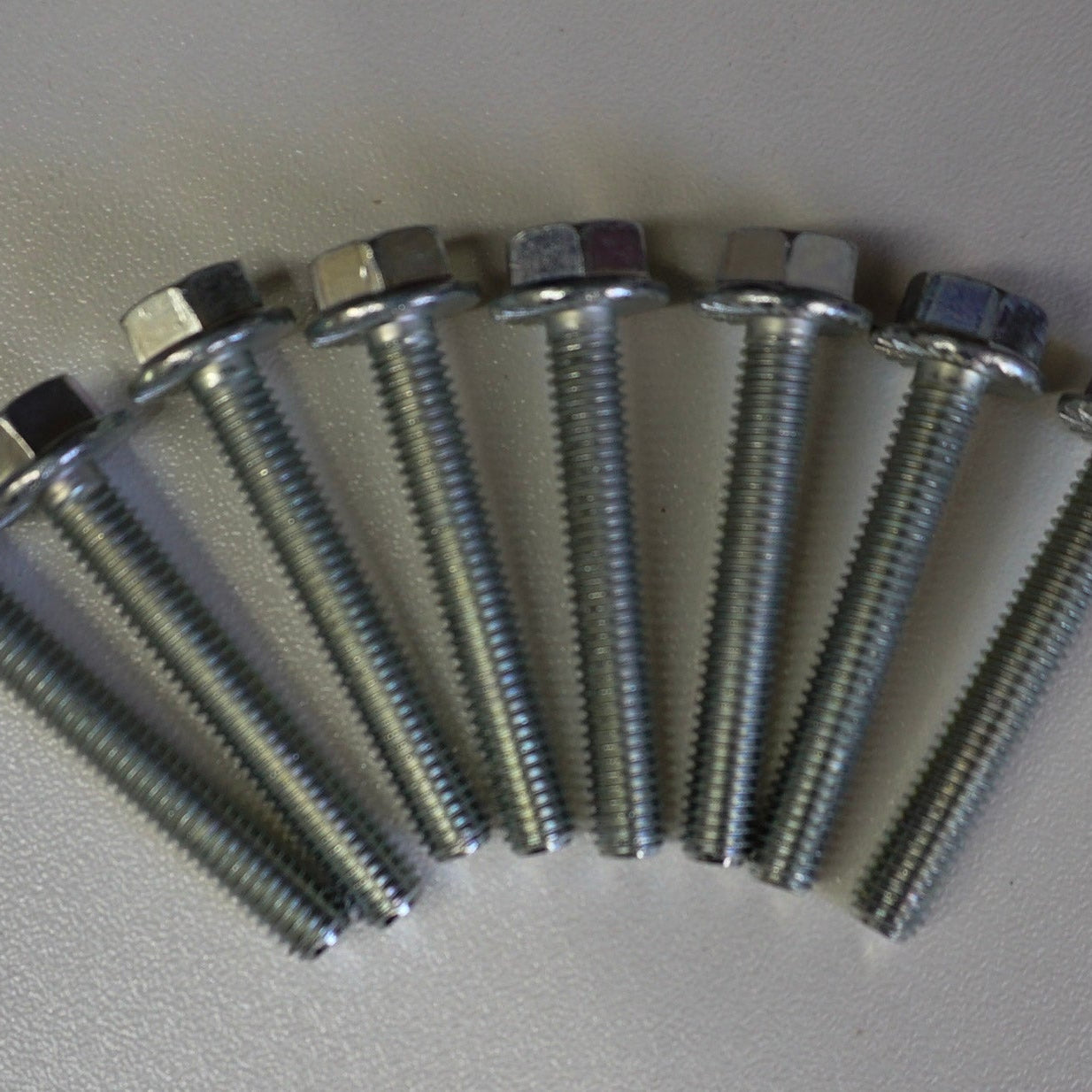 Set of metal screws on a gray background
