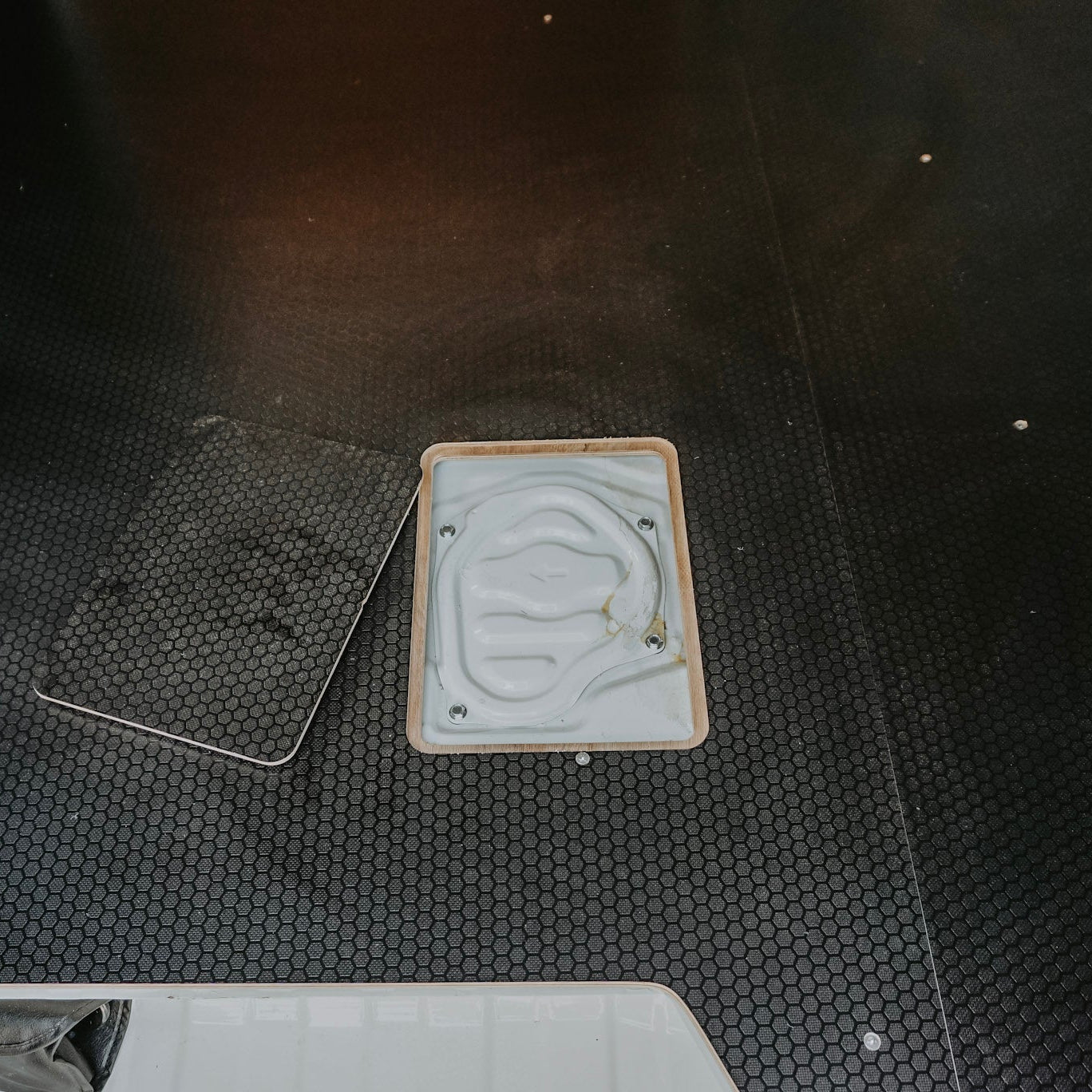 Two square objects on a textured black surface