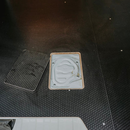 Two square objects on a textured black surface