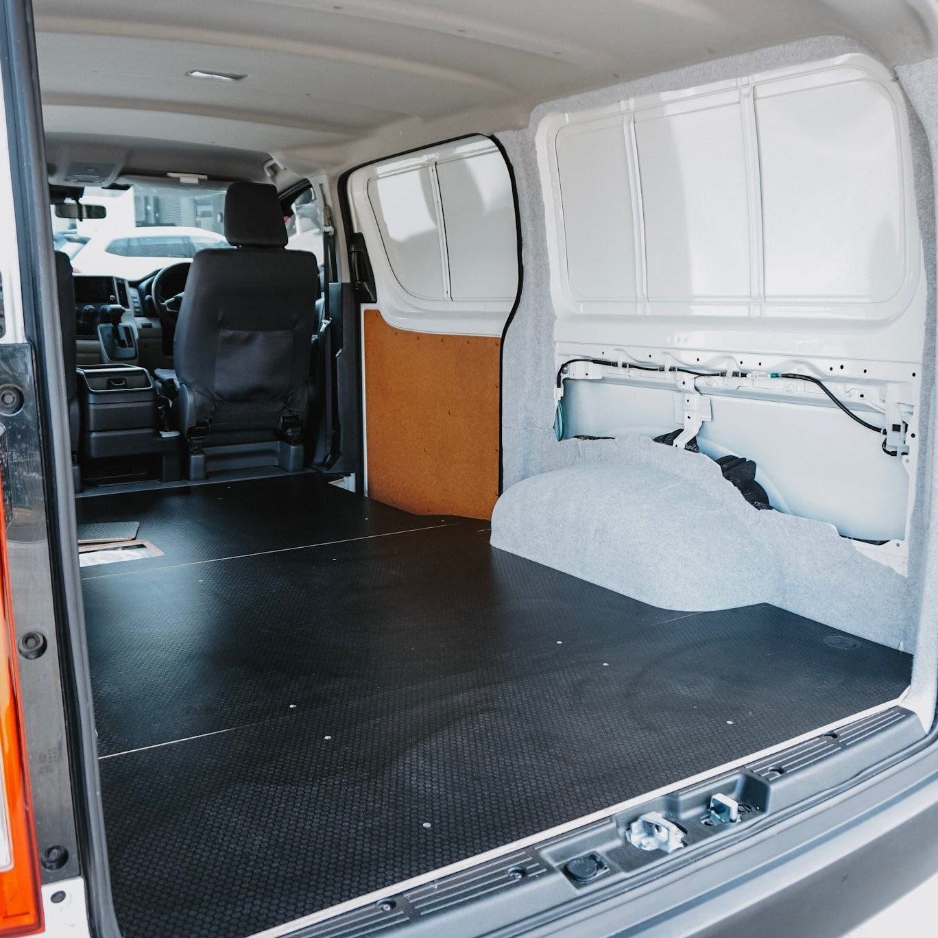 Van interior with a flatbed and folded seat, ready for cargo.
