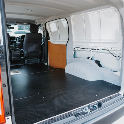 Van interior with a flatbed and folded seat, ready for cargo.