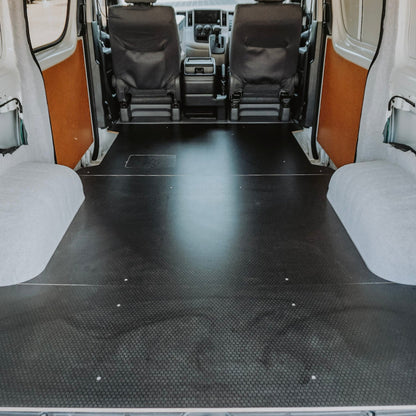 Van interior with a black floor mat and white walls.